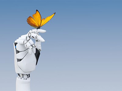 Photo of a robot hand gently holding a delicate butterfly