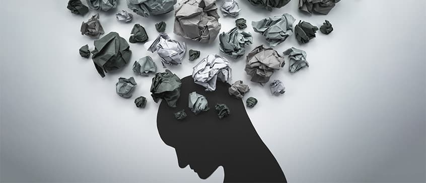 Illustration with crumpled up balls of paper over a silhouette of a person. 
