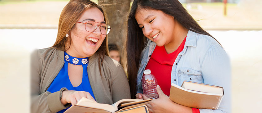 Indigenous students looking at a book