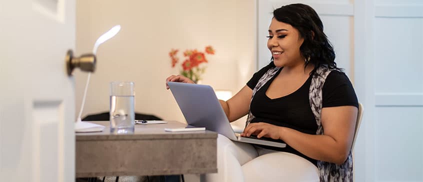 Photo of indigenous woman holding laptop