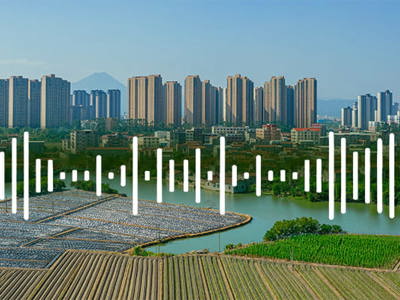 Panoramic view of a modern city skyline with high-rise residential buildings in the background, overlooking agricultural fields and farmland in the foreground, with a translucent overlay of white data visualization bars resembling an audio waveform or statistical chart, and a subtle ghosted profile of a human head on the right side, symbolizing the intersection of urban development, environmental factors, and human health analysis.