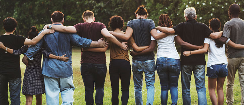 Photo of group of people linking arms. 