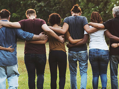 Photo of group of people linking arms.