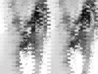 Black and white double exposure of a person clutching their head, with their face looking down and obscured by a dissolving, granular texture.