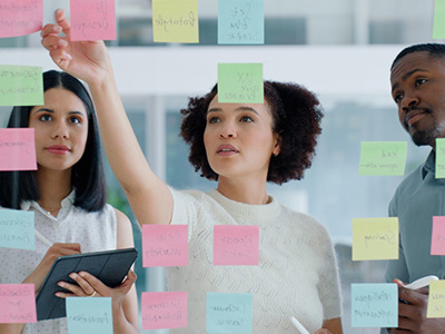 A number of wooden figures in a variety of flesh colours sitting in a networked configuration