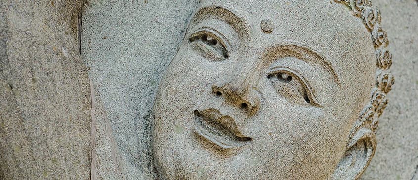 Bas-relief of a smiling face of Buddha gazing upwards