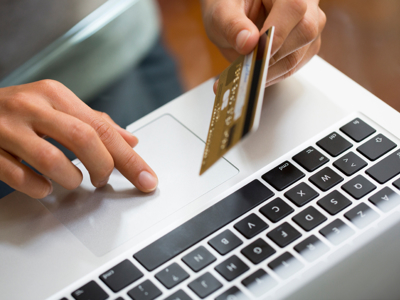 closeup of credit card beside laptop