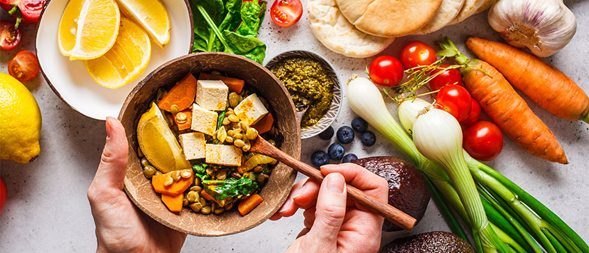 Photo of healthy power bowl with a background of various vegetables. 