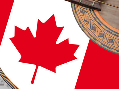 Close-up of an acoustic guitar with a Canadian flag design on its body, placed over sheet music, symbolizing Canadian musical heritage and iconic artists.