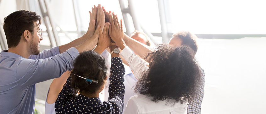 Photo of team members with hands joined.