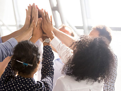 Photo of team members with hands joined.