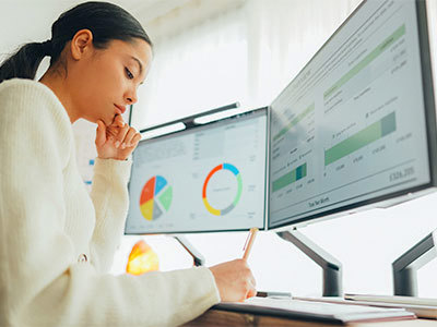 Woman with graphs and charts open on computer display