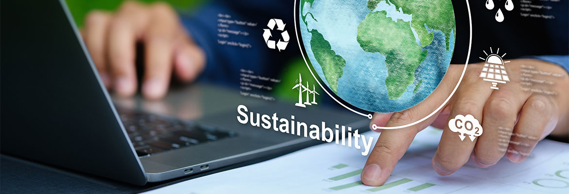 Closeup of hands working at laptop with a conceptual globe illustration and sustainability concepts around it.