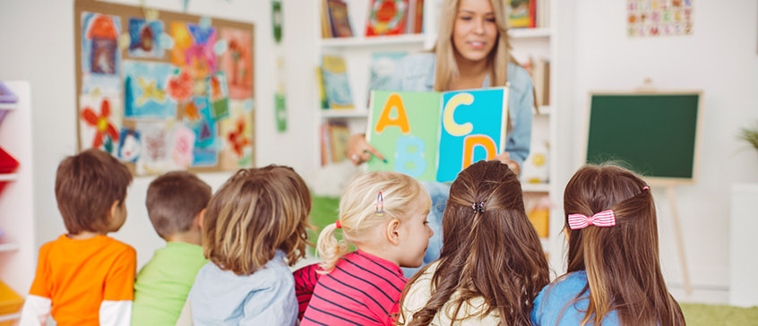 An elementary school teacher teaching 6 young students.