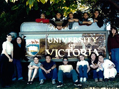 Black and white photo of ELC students in front of the University of Victoria sign