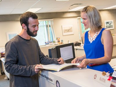 A photo of a student asking a question to the registration staff